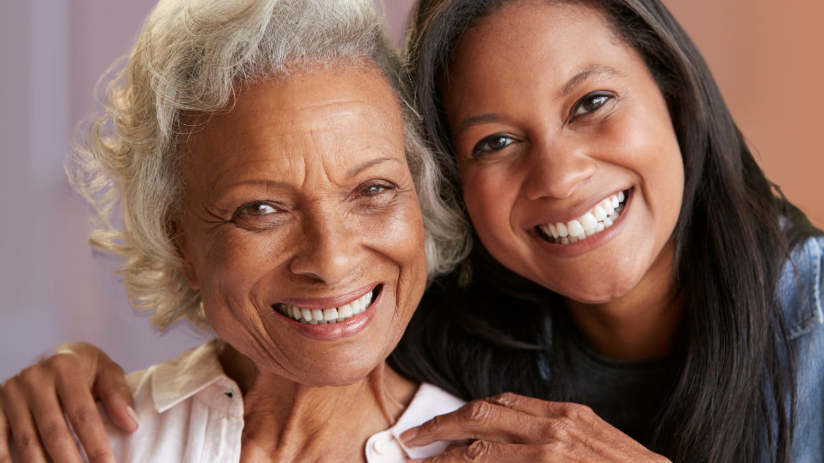 Mother and Adult Daughter Caregiver smiling at the camera