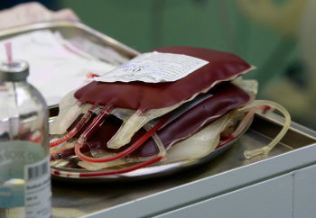 Bags of donated blood before a transfusion, sitting on a table during a surgery