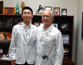 Eric Wang, 20, (left) learned more from Richard W. Smalling, MD, PhD, (right) professor with McGovern Medical School at UTHealth Houston, about how research is impacting ways to improve health disparities. (Photo by UTHealth Houston)