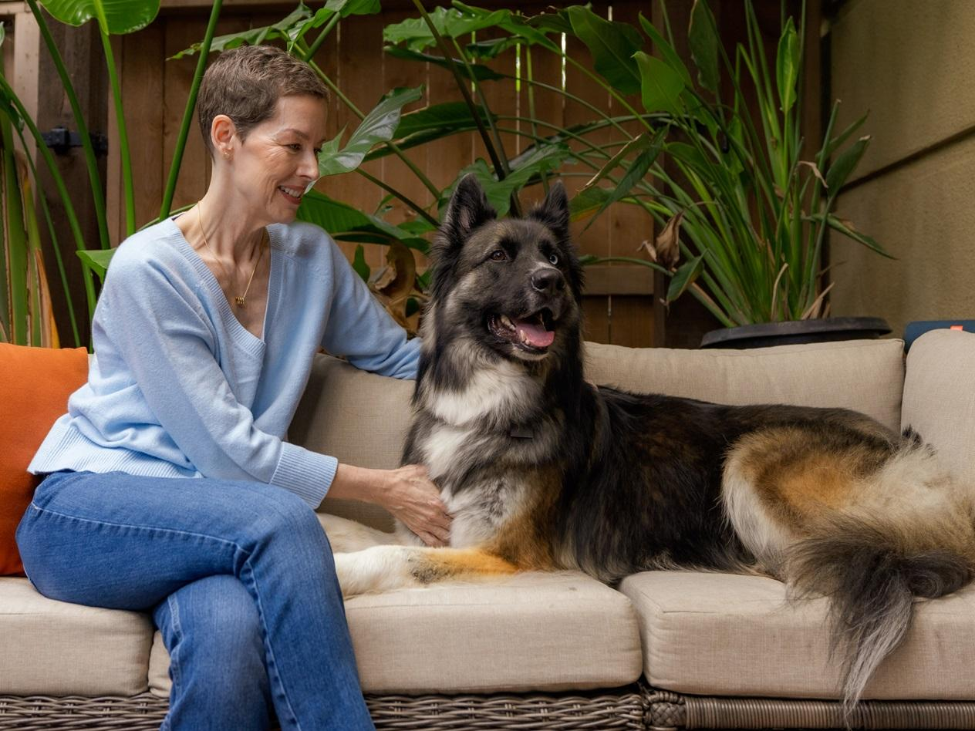 Kim Charlton sitting on a couch with her dog