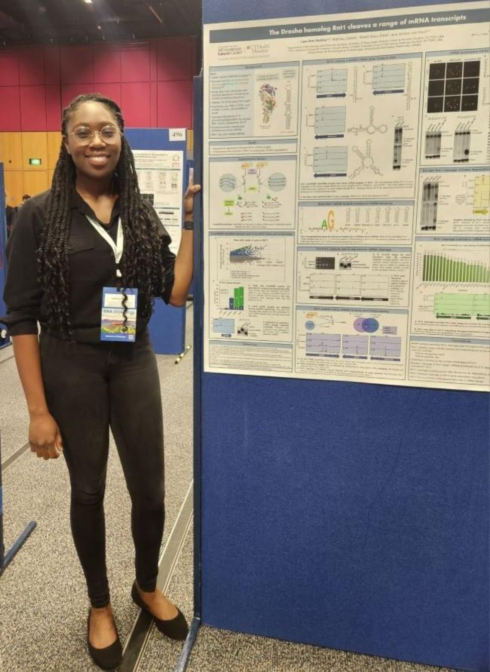 Notice-Sarpaning standing by poster at RNA 2024.