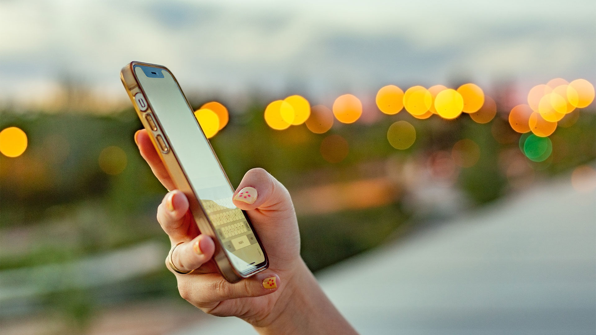 Woman's hand holding a phone outside