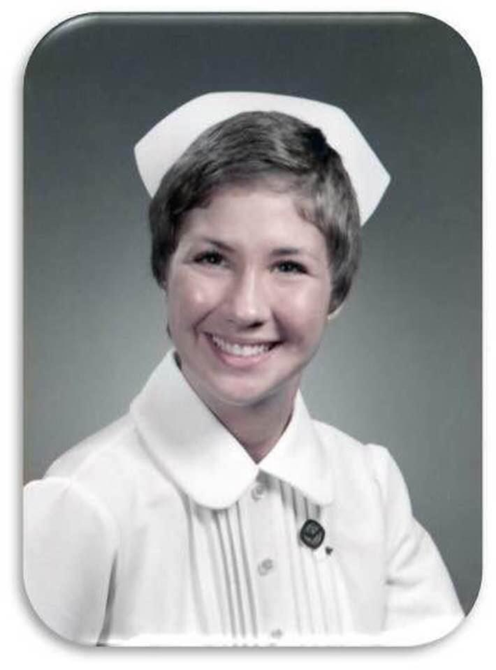 A woman smiles for her nursing school photo