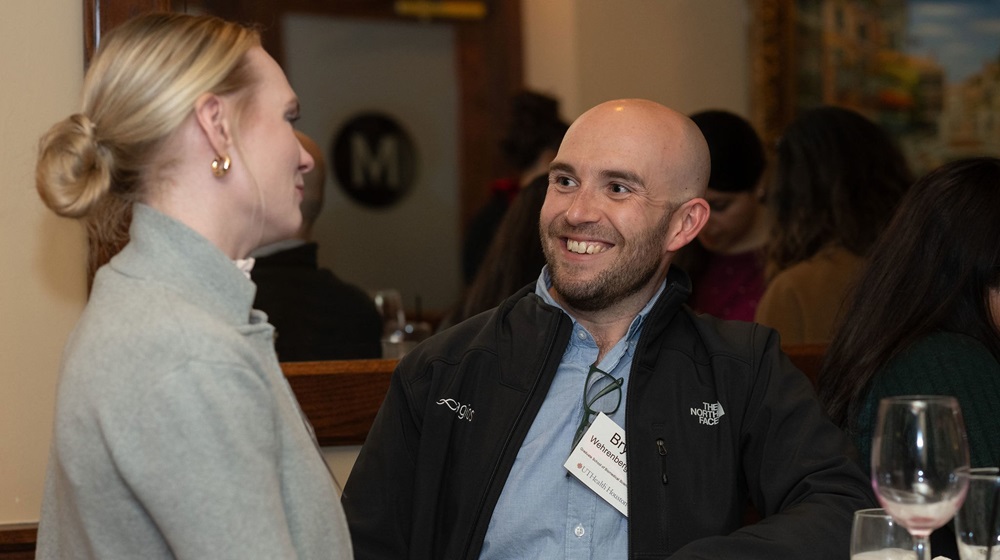 Male and female alumni talking at an event