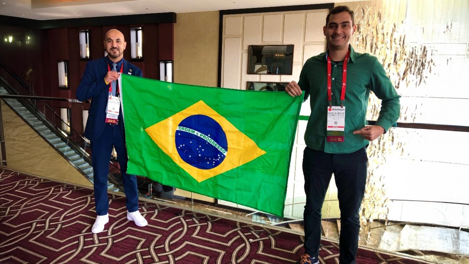 Image of Dr. Augusto César Ferreira De Moraes, PhD, MSc, Bs, and Dr. Marcus Nascimento-Ferreira, PhD, Federal University of Tocantins, Brazil standing and holding a Brazilian flag between them.